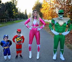 two people in costumes standing next to each other on a road with trees behind them