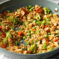 a pan filled with rice and vegetables on top of a table