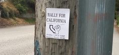 a sign posted on a telephone pole that says rally for california