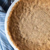 an uncooked pie sitting on top of a table next to a blue towel