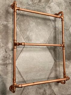 an old fashioned copper towel rack on a tiled wall in a bathroom with tile flooring