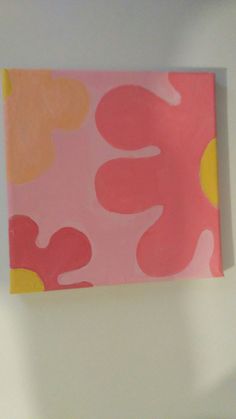 a pink and yellow painting hanging on the wall