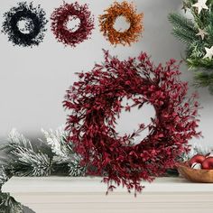 christmas wreaths and decorations on a mantel