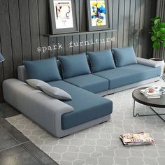 a blue and gray couch sitting in a living room next to a table