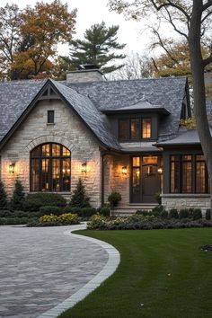 a large house with lots of windows and lights on it's front door is shown