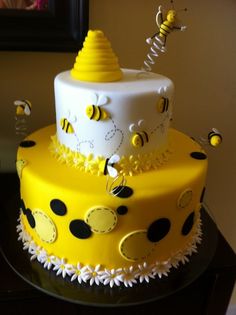 a yellow and white cake with bees on it