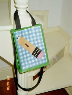 a small bag with a design on it sitting on top of a white chair next to a wooden floor