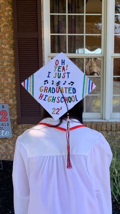 a person wearing a graduation cap with writing on it