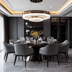 an elegant dining room with black walls and marble flooring, chandelier above the table