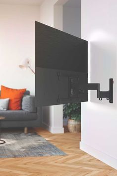 a flat screen tv mounted to the side of a white wall in a living room