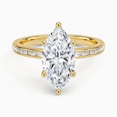 a yellow gold ring with a pear shaped diamond in the center and side stones on each band