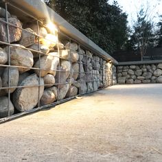 a bunch of rocks are stacked up in a fenced area next to a building