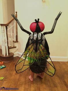 a person standing on the floor with their arms in the air while wearing a costume