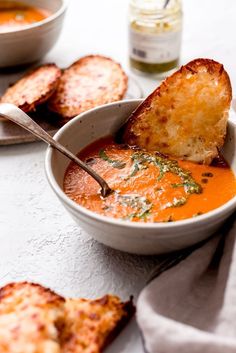 a bowl of tomato soup with grilled bread on the side