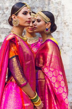 two women dressed in bright pink and yellow outfits, one is kissing the other's forehead