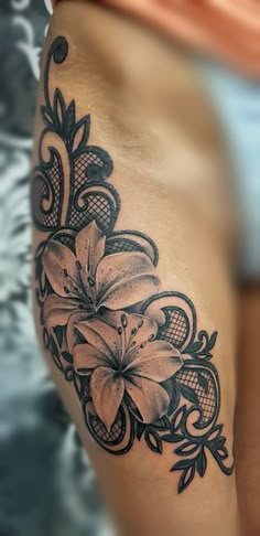 a woman's thigh with flowers on it and an intricate design in the middle