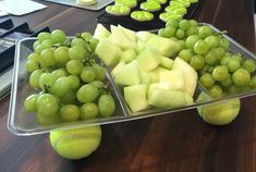 grapes and green apples are arranged on trays