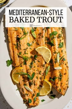 a white plate topped with grilled salmon and lemons