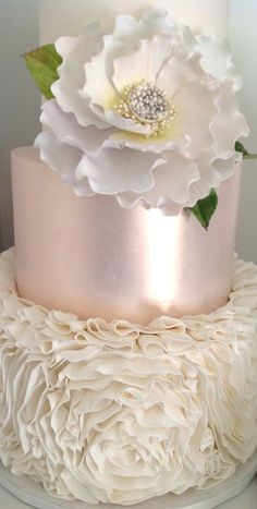 a wedding cake with white flowers on top and pink icing around the edges, is featured on instagram