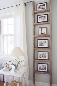 an old ladder is used as a shelf for pictures