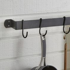 a pot and pan hanging from a hook on a wall