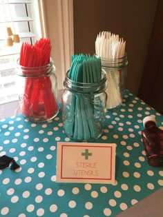 the table is set up with toothbrushes in mason jars and paper straws