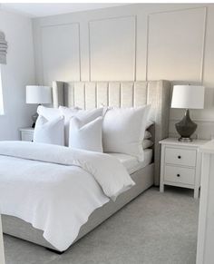 a bed with white sheets and pillows in a bedroom