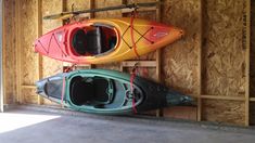 two kayaks hanging from hooks in a garage