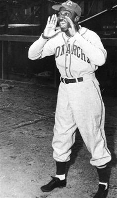 an old black and white photo of a baseball player holding his hand up to his face