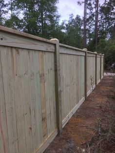 a wooden fence in front of some trees