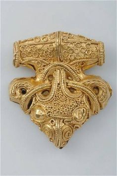 a gold brooch with intricate designs on it