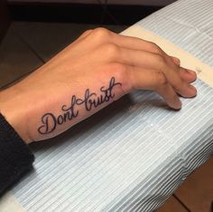 a person's hand with a tattoo that says don't trust