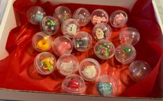 a box filled with lots of small plastic toy animals on top of a red cloth