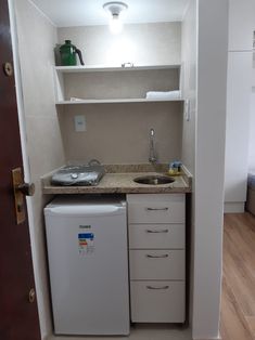 a small kitchen with a sink and refrigerator