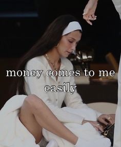 a woman sitting on top of a bed next to a white blanket with the words money comes to me easily