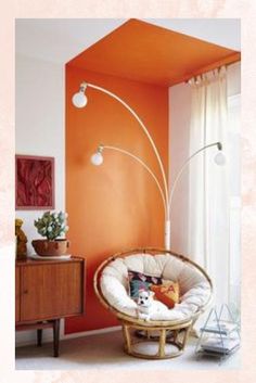 a living room with an orange accent wall and white carpeted flooring is shown