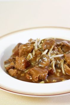 a white plate topped with meat and gravy