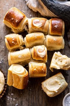 several rolls with butter on them sitting next to a glass of milk and some other food items