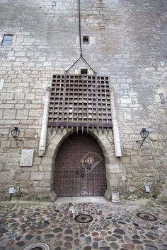 an old stone building with a door and window on the outside wall, surrounded by cobblestones