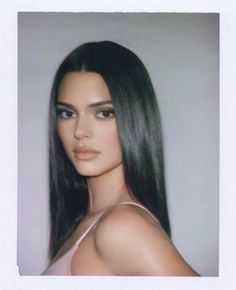 a woman with long black hair posing for a photo