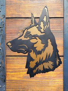 a metal wolf head mounted on a wooden wall