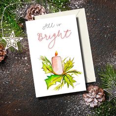 a christmas card with a lit candle surrounded by pine cones