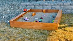 an outdoor sandbox with toys in it