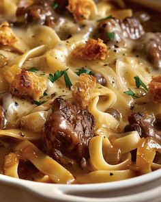 a white bowl filled with pasta and meat