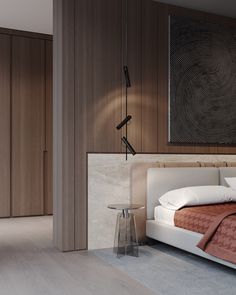 a large bed in a bedroom next to a wall mounted lamp and wooden paneled walls