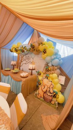 a winnie the pooh birthday party with balloons and honeybees on it's walls