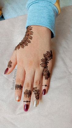 a woman's hand with henna tattoos on it