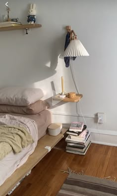 a bed sitting on top of a wooden floor next to a lamp