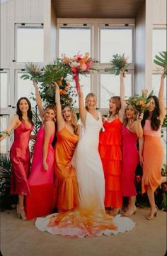 a group of women standing next to each other in front of a window holding up their arms