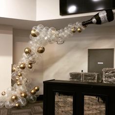 an arch made out of balloons and wine bottles is displayed in the lobby at a business